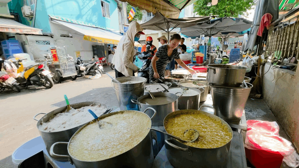 Pots of Vietnamese sweet soup (chè) prepared at a bustling Saigon street food stall