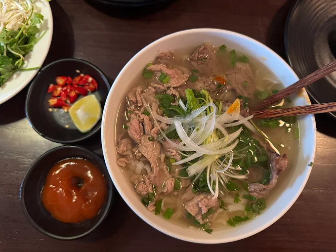 Beef noodle soup served with herbs and lime recommended by Michelin Guide