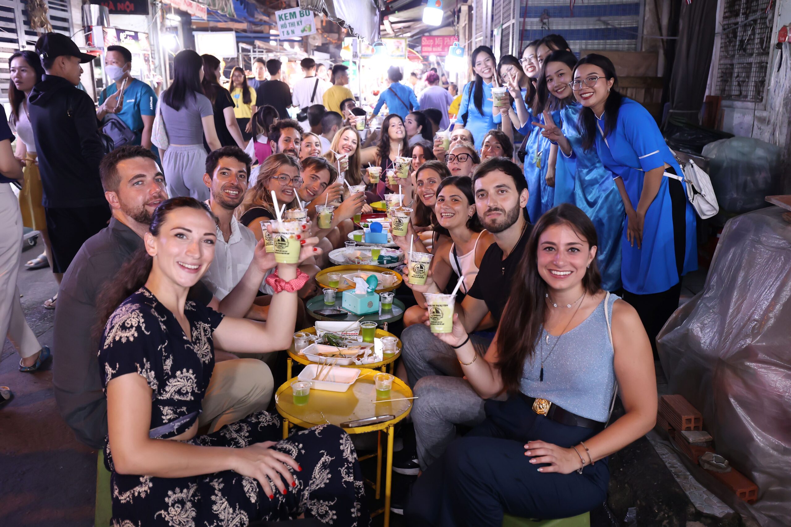 Guests and Ao Dai guides enjoying desserts together during a Michelin food tour in Ho Chi Minh City — part of an authentic Saigon food tour experience in Vietnam.