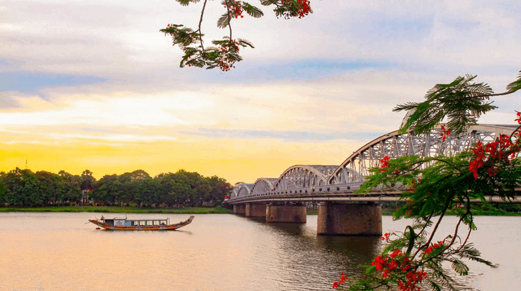 Sunset view of the Perfume River and Truong Tien Bridge in Hue, Central Vietnam - a peaceful scene near the Imperial Citadel, where visitors can enjoy dragon boat rides and local cafés along the riverside.