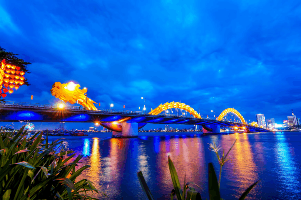 The Dragon Bridge illuminated at night over the Han River in Da Nang, Central Vietnam - a modern landmark known for its dragon-shaped design that breathes fire and water on weekends.