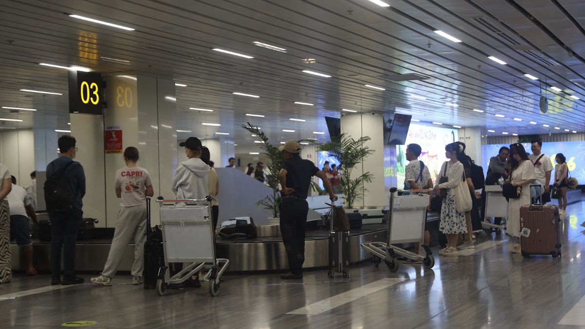 Travellers with luggage at airport counters in Vietnam, where a KissTour host meets arriving families