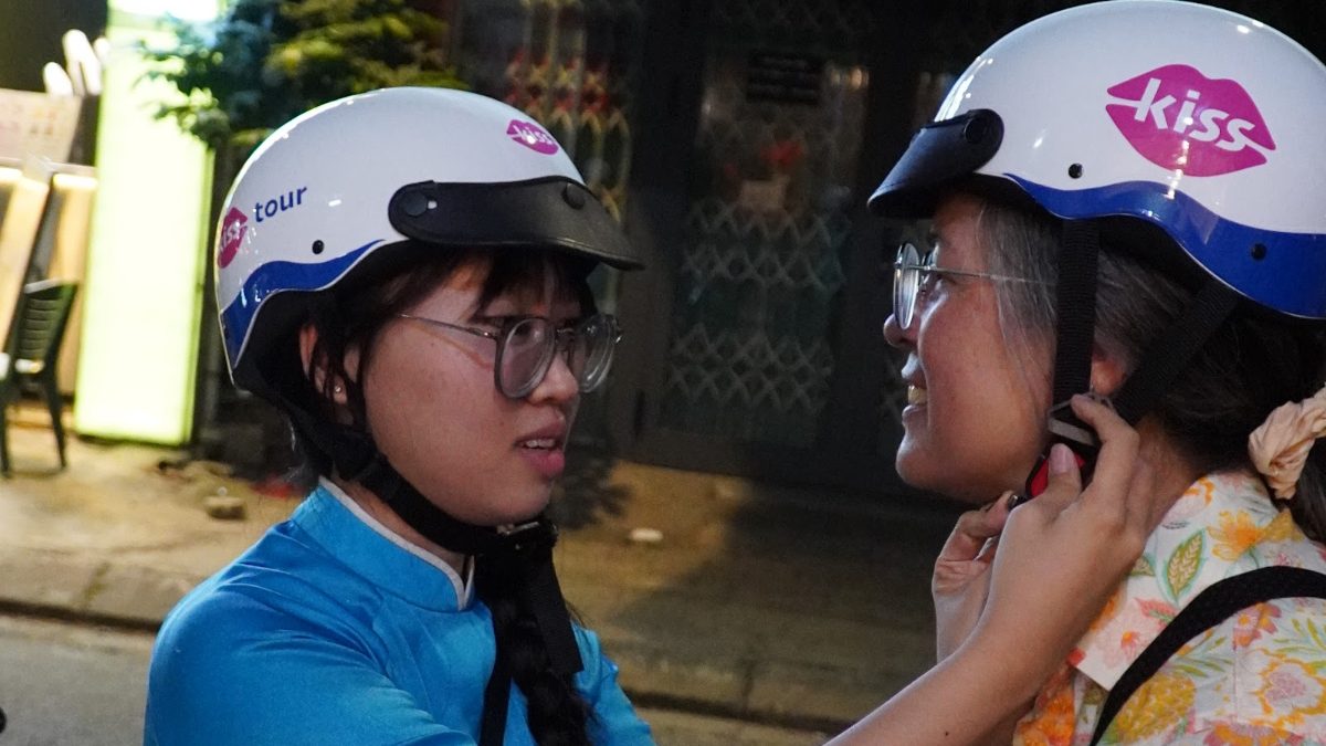 KissTour lady driver fitting a guest helmet on the Da Nang by night tour