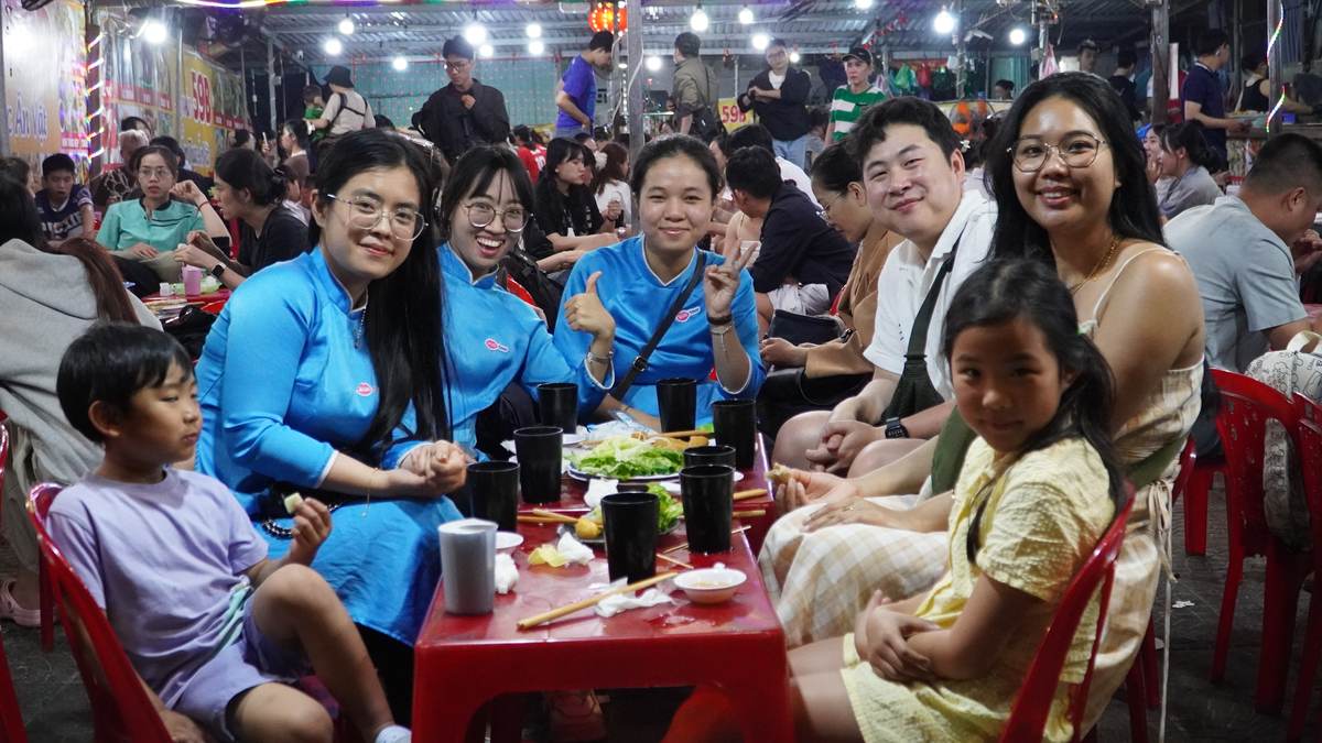 Travelers and KissTour guides enjoying street food at a Da Nang night market