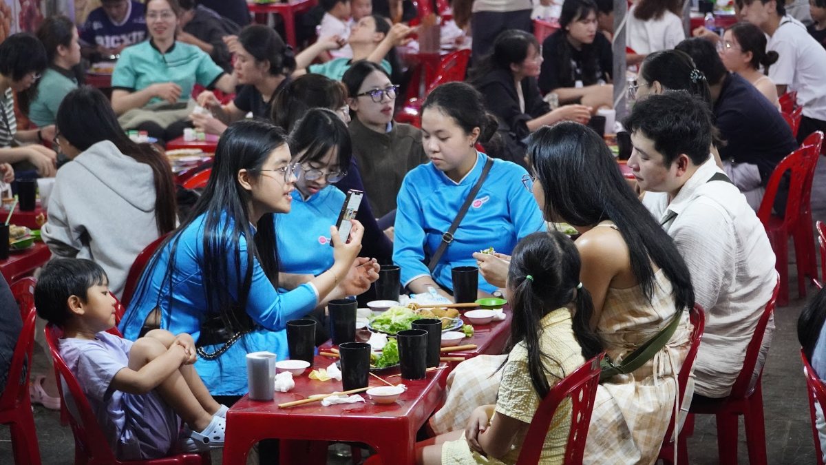 Guests eating at a Da Nang street food stop at night with KissTour guides