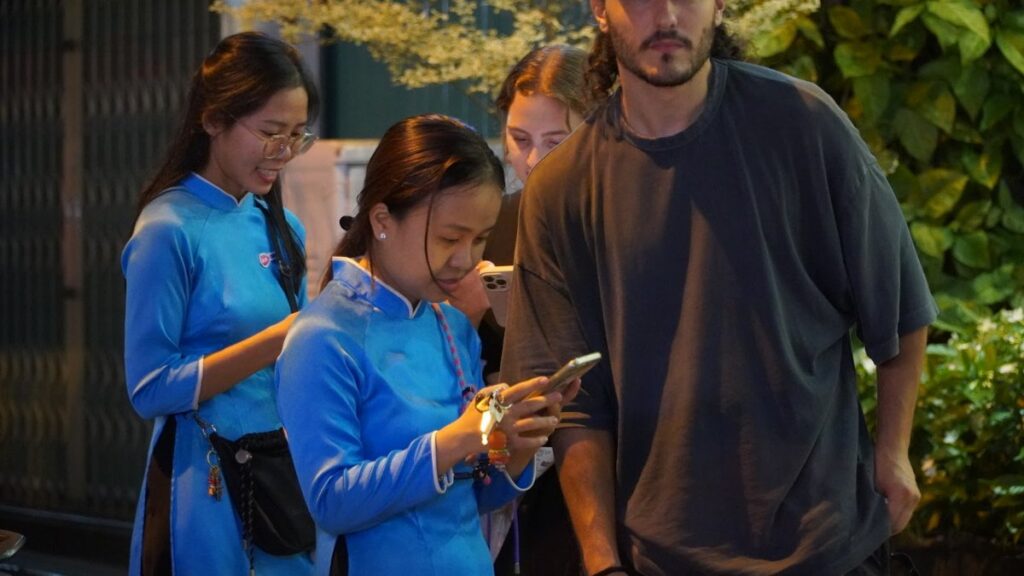 First time in Saigon — KissTour guides in blue ao dai welcoming guests at the start of an evening tour in Ho Chi Minh City