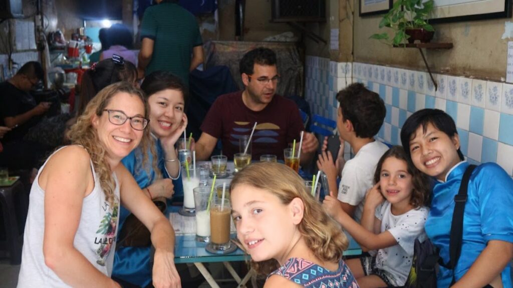 Family and KissTour guides sharing local drinks on a Saigon food tour with kids