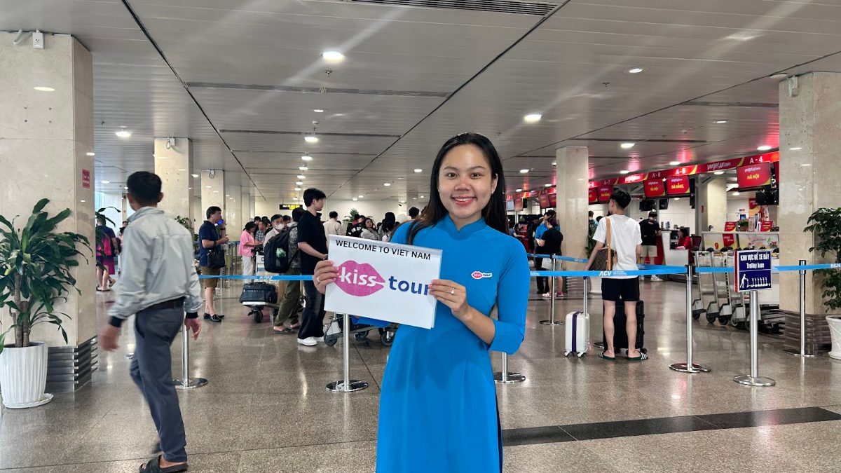 KissTour fast track greeter holding a welcome sign in the airport arrivals area