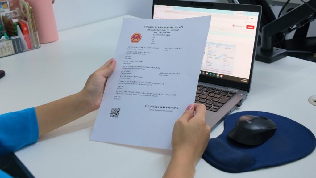 KissTour visa team member reviewing a printed Vietnam e-visa approval letter at the office