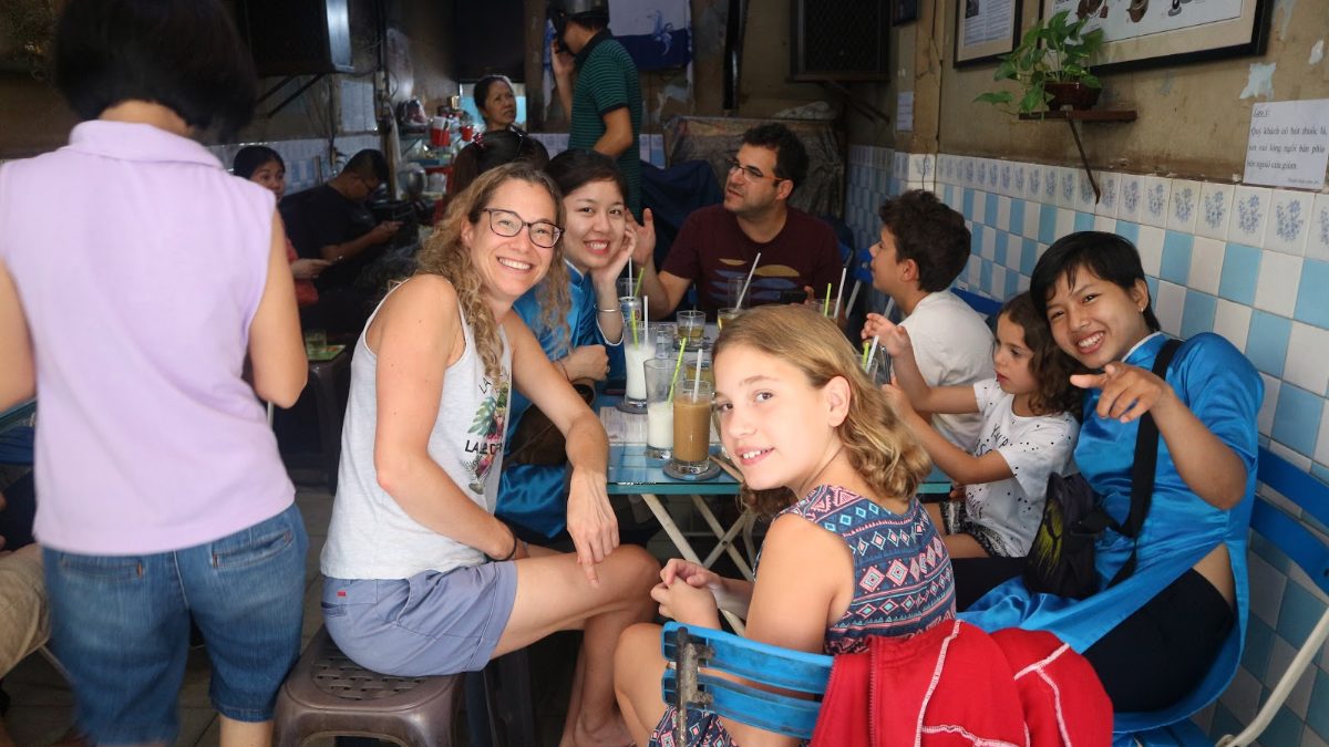 Kids and parents trying Vietnamese drinks at a local stop on a Saigon food tour with kids