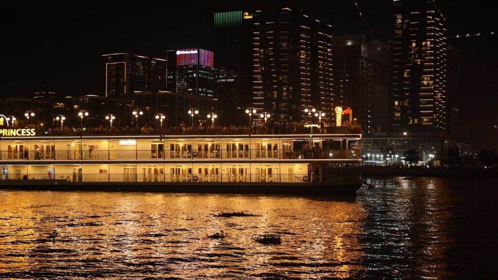 Saigon river dinner cruise boat at Bach Dang Wharf with the city skyline at night