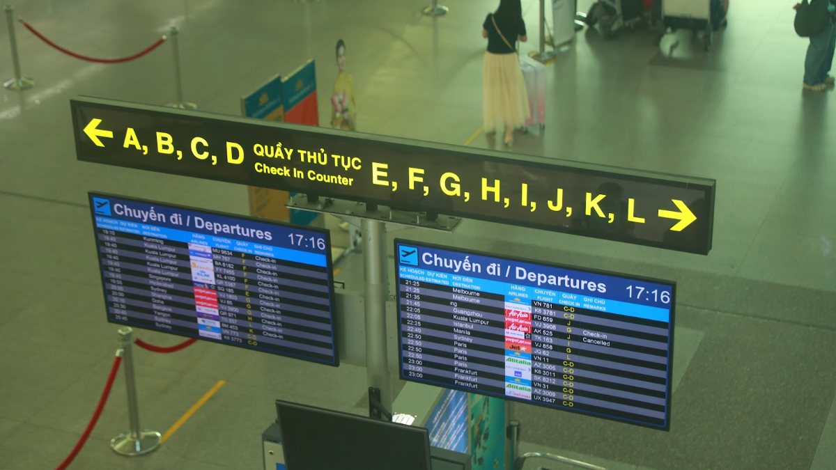 Flight information board and check-in zone signage inside the terminal at Tan Son Nhat