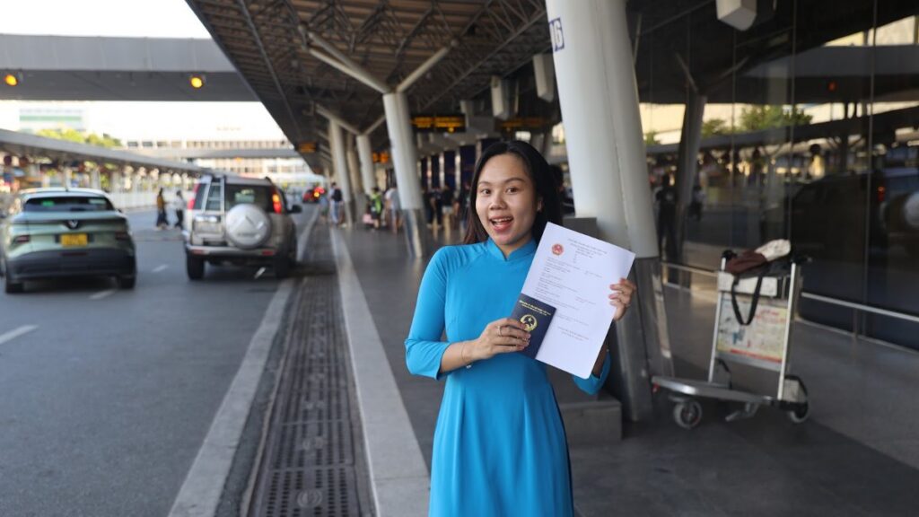 KissTour greeter holding a welcome sign at the airport kerbside, the meeting point for Vietnam fast track for families