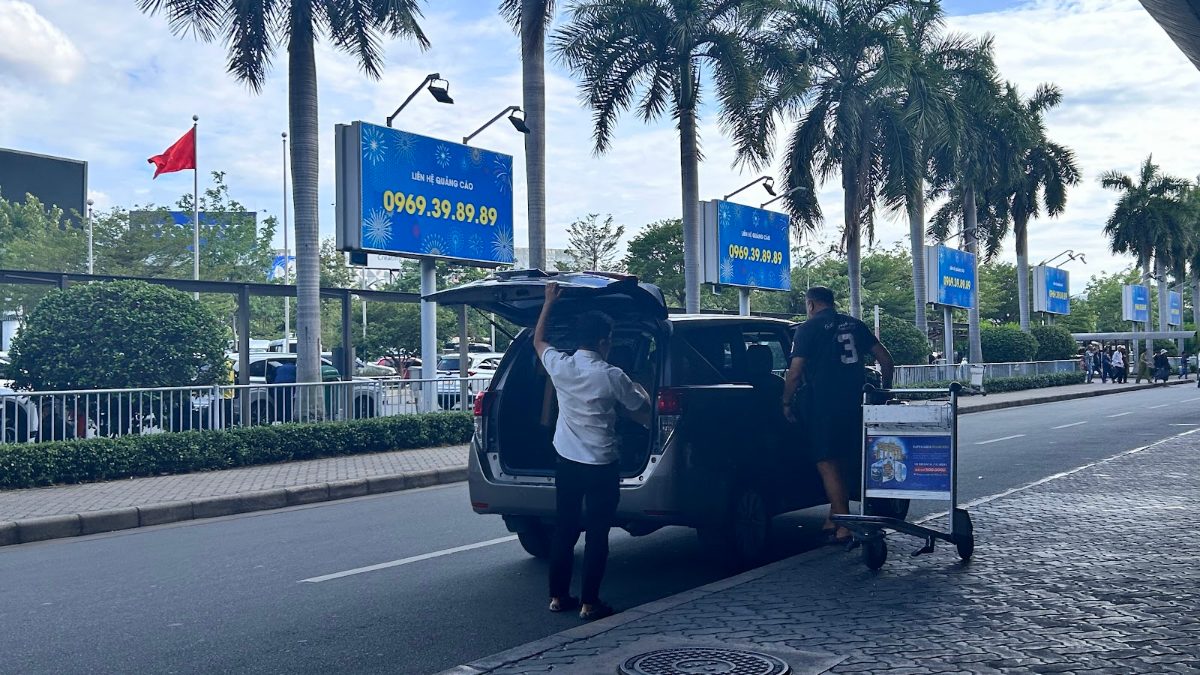 After the Vietnam visa fast track combo, a KissTour driver loads luggage for the curbside car pickup at Tan Son Nhat
