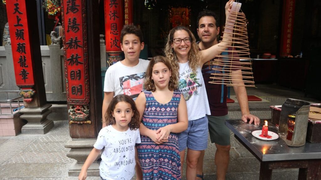 Family exploring Vietnam with kids at Thien Hau Temple in Ho Chi Minh City, incense coils overhead