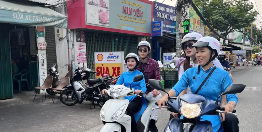 Guest riding on the back of a KissTour scooter through Ho Chi Minh City