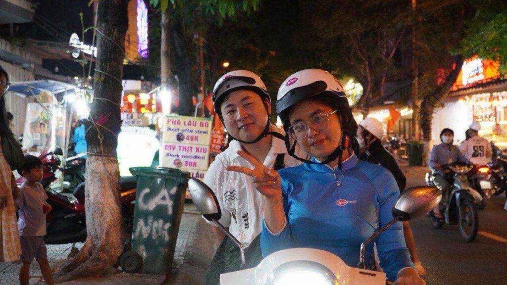 KissTour guests on scooters, Da Nang street at night