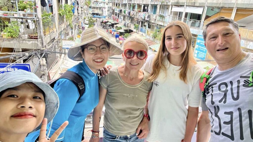 Group with guide on a Saigon street of old apartments
