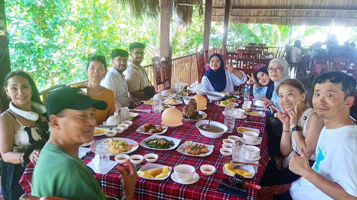 Group lunch at a riverside garden restaurant on a Mekong Delta day trip from Saigon