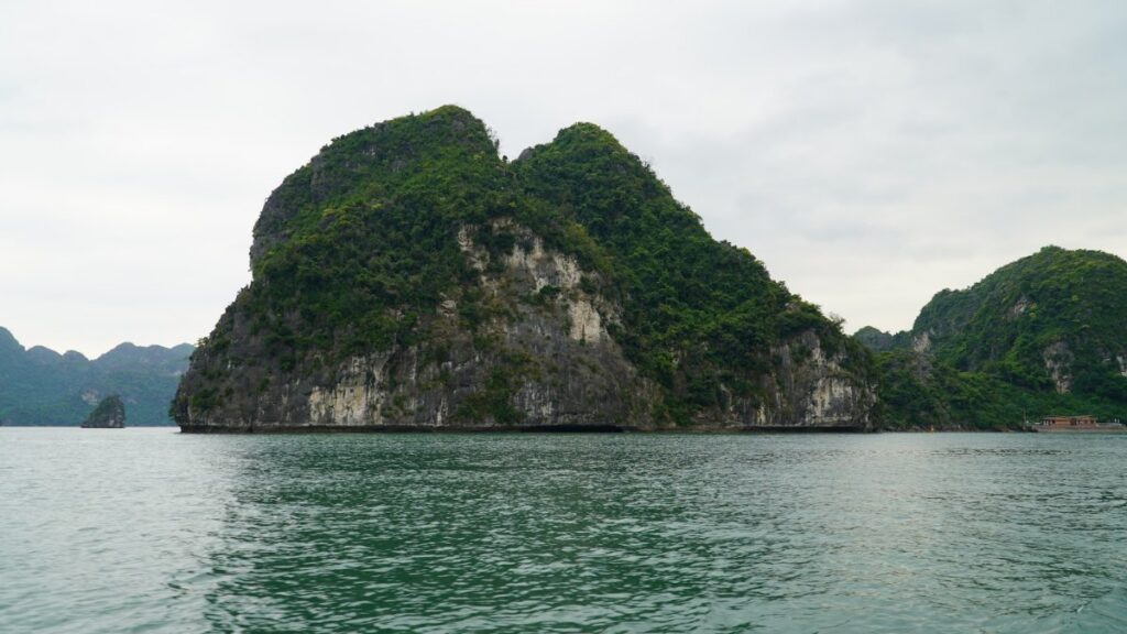 Limestone karst rising from the emerald water of Ha Long Bay, compared with Ninh Binh
